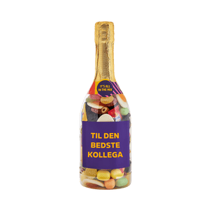 Champagneflaske fyldt med farverigt slik med teksten TIL DEN BEDSTE KOLLEGA på etiketten. Gaveidé fra SlikEkspressen.