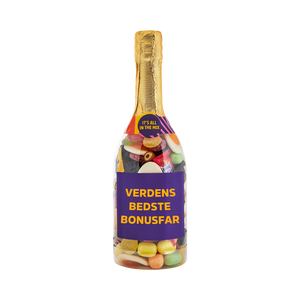 Champagneflaske fyldt med slik og lilla etiket med teksten "Verdens Bedste Bonusfar" – sød gave fra SlikEkspressen.