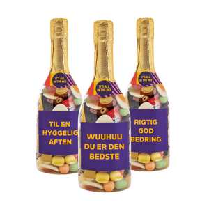 Tre champagneflasker fyldt med Bland Selv Slik fra SlikEkspressen med etiketterne “Til en hyggelig aften”, “Wuuhuu du er den bedste” og “Rigtig god bedring”.