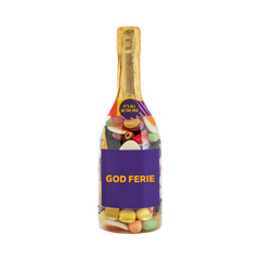 Champagneflaske fyldt med slik og lilla etiket med teksten "God ferie" – sød gave fra SlikEkspressen.