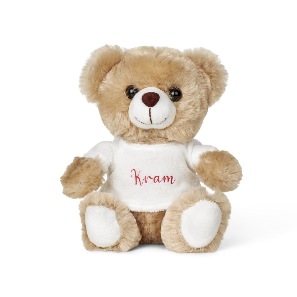 Sødt plysdyr med trøje med teksten Kram – blød krammebamse i beige og hvid.