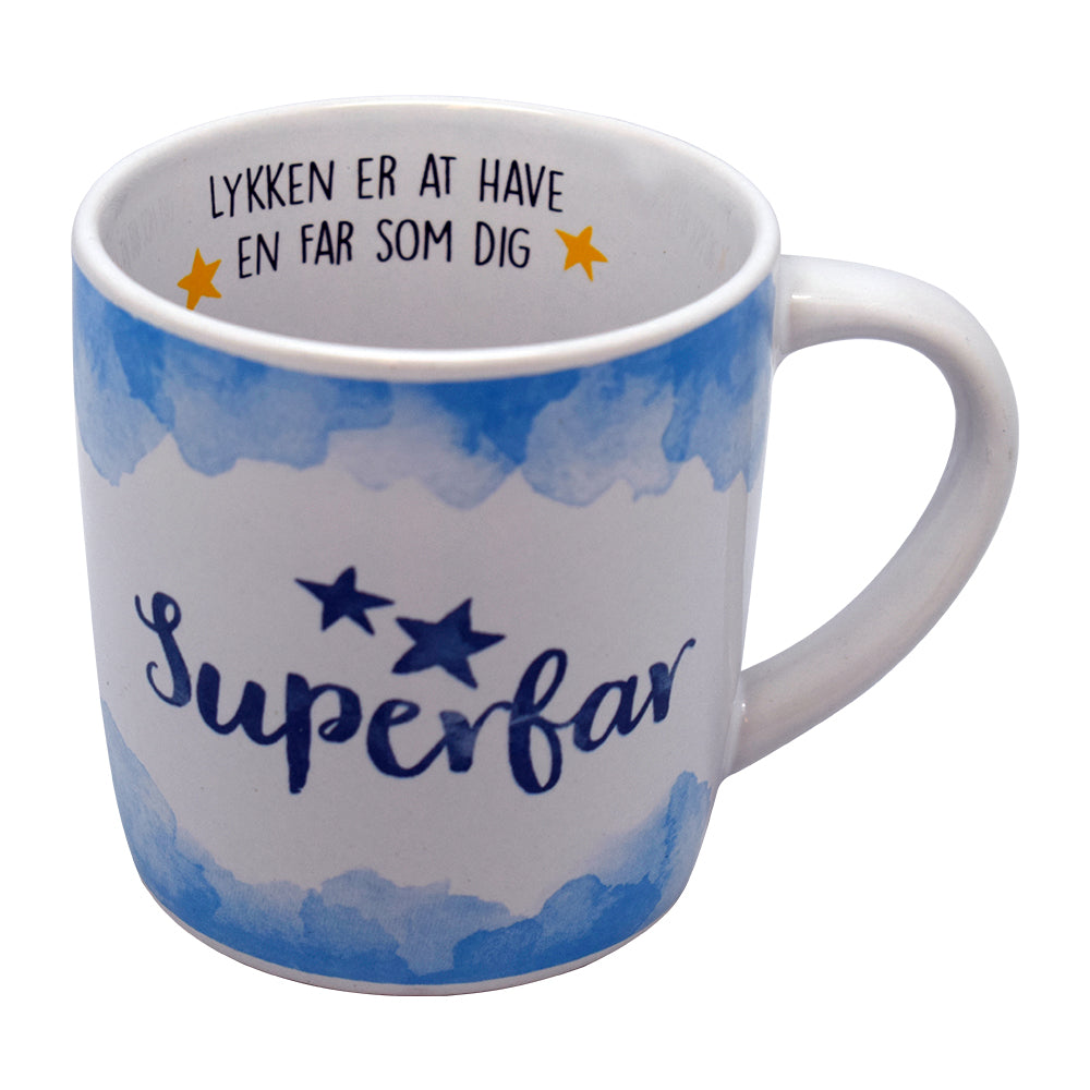 Hvid kop med blå detaljer og teksten "Superfar" udenpå samt "Lykken er at have en far som dig" indeni – oplagt gave til Fars Dag.