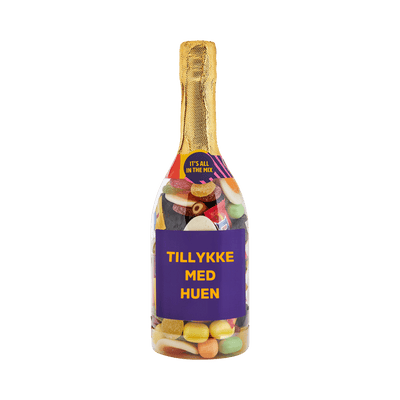 Champagneflaske fyldt med farverigt slik med teksten TILLYKKE MED HUEN på etiketten. Gaveidé fra SlikEkspressen.